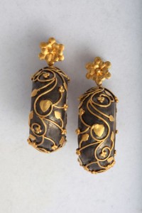 A pair of earrings with gold and black designs.
