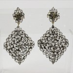 A pair of diamond earrings with white stones.