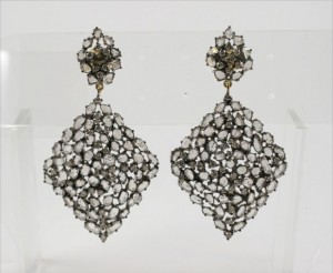 A pair of diamond earrings with white stones.