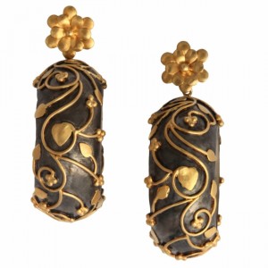 A pair of earrings with gold and black designs.