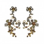 A pair of earrings with gold and silver flowers.