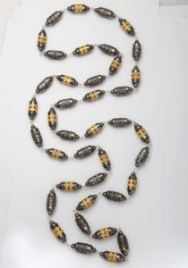 A long necklace of gold and black beads.