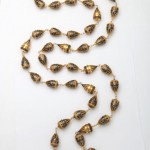 A long necklace of gold and black beads.