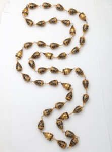 A long necklace of gold and black beads.