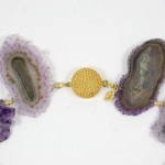 A close up of two purple and gold necklaces