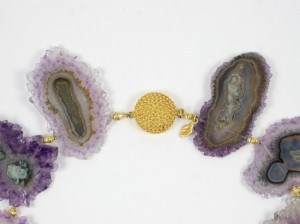 A close up of two purple and gold necklaces
