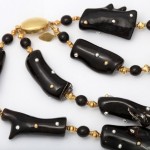 A black and gold necklace with white beads.