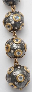 A close up of the necklace with some gold and silver