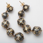 A pair of black and gold earrings with white diamonds.