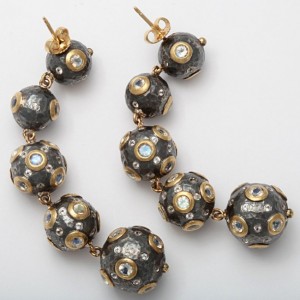 A pair of black and gold earrings with white diamonds.
