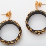 A pair of black and gold earrings on a white background