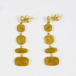 A pair of gold earrings with three different designs.