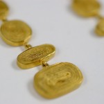 A close up of some gold coins on a white surface