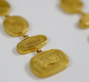 A close up of some gold coins on a white surface