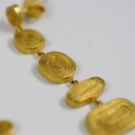 A close up of some gold jewelry on a white surface