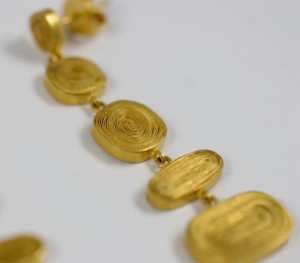 A close up of some gold jewelry on a white surface