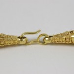 A close up of the clasp on a gold chain