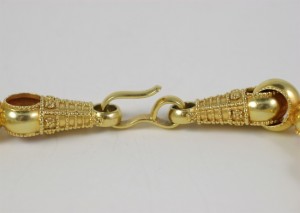 A close up of the clasp on a gold chain