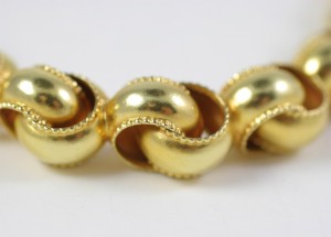 A close up of gold beads on a white surface