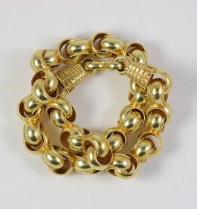 A gold chain bracelet with two large links.