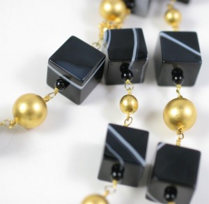 A close up of a necklace with black and gold beads