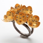 A ring with flowers made of metal and gold.