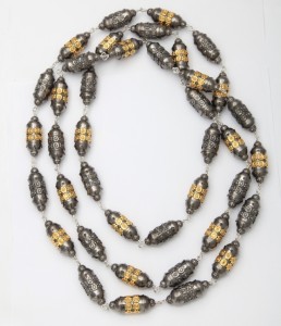 A long necklace with gold and black beads
