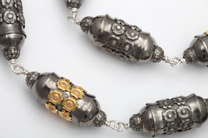 A close up of the necklace with two different beads