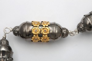 A silver and gold key chain with flowers on it.