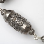 A close up of the silver bead on the necklace