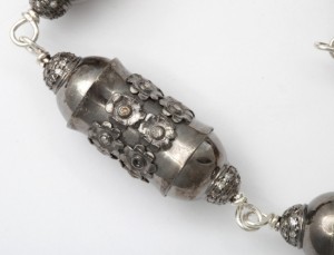 A close up of the silver bead on the necklace