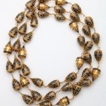 A long necklace of gold and black beads.