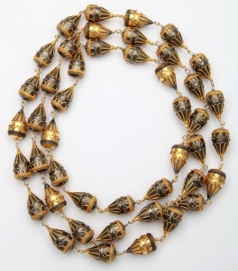 A long necklace of gold and black beads.