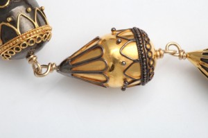 A close up of the gold and black jewelry.