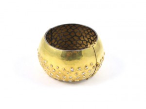 A gold bangle with some diamonds on it