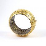 A gold and silver bracelet with a metal ring around it.