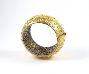 A gold and silver bracelet with a metal ring around it.