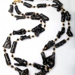 A long necklace of black beads and gold