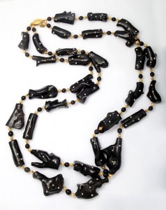 A long necklace of black beads and gold