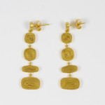 A pair of gold earrings with three squares hanging from them.