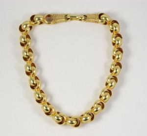 A gold chain necklace with a clasp on the end.