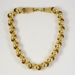 A gold chain necklace with a clasp on the end.