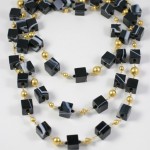 A long necklace of black and gold beads.