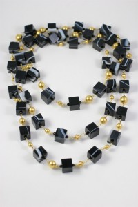 A long necklace of black and gold beads.