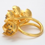 A gold ring with black diamonds on it