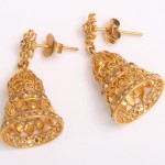 A pair of gold earrings with filigree design.