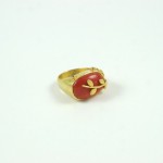 A gold ring with a red stone on it