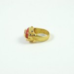A gold ring with a red stone on it