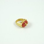 A gold ring with red stone on top of it.