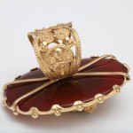 A gold ring sitting on top of a red object.